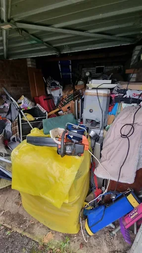 Garage packed with furniture, tools and bagged items before clearance, typical of jobs we clear in Poole