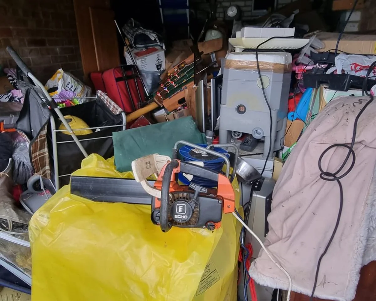 Garage crammed with tools, electricals and household overflow before clearance